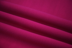 Magenta solid vortex-yarn woven fabric with a clean surface